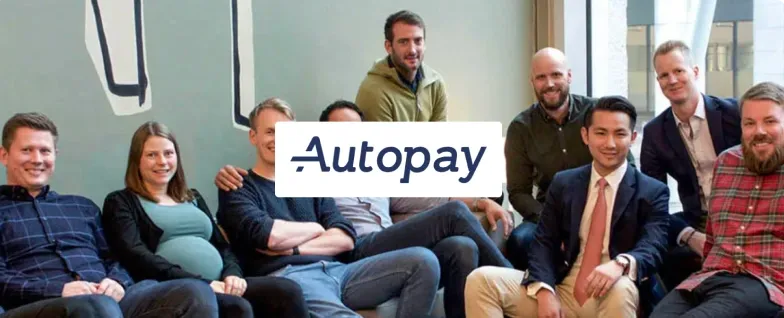 Autopay team members gathered together with the Autopay logo.