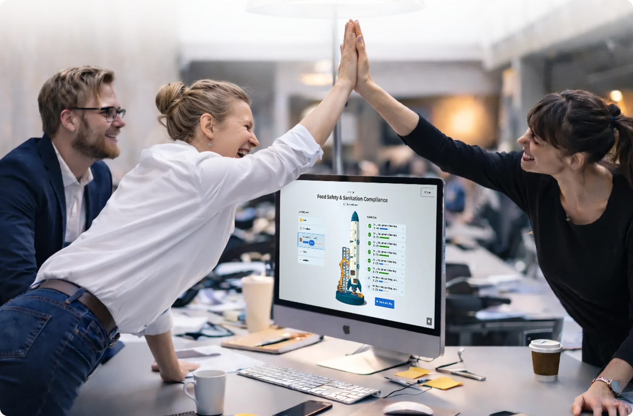 Two colleagues high-fiving across a desk with a Kahoot 360 course on screen
