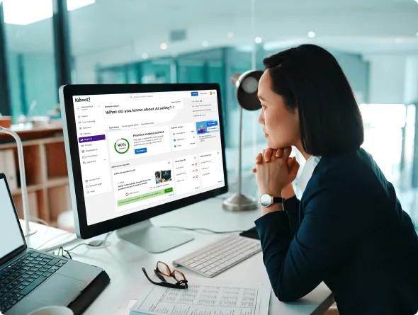 Woman thoughtfully viewing a Kahoot quiz question about failure on her desktop computer in a bright office