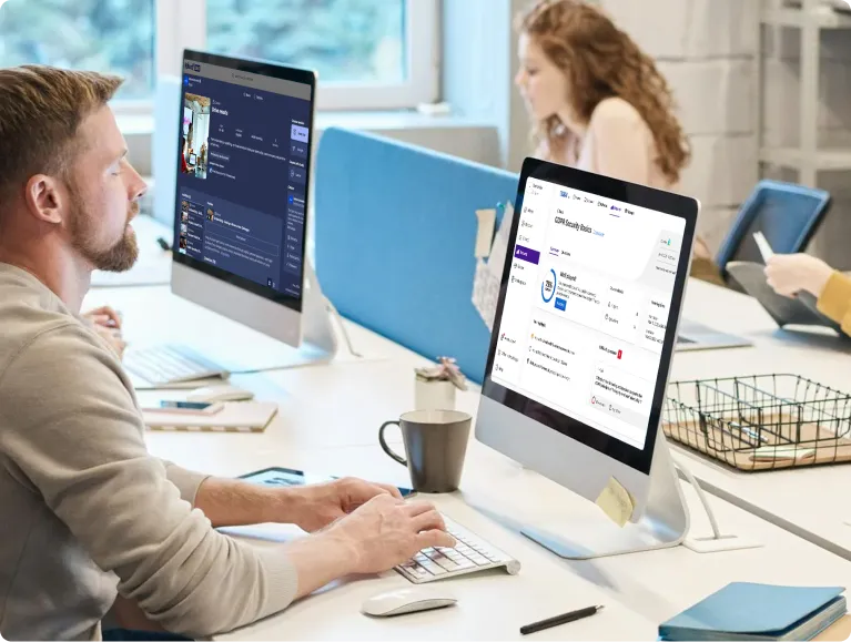 Man working at a desktop computer with Kahoot platform open in a modern office, colleague using a tablet in the background