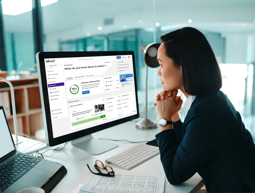 Woman thoughtfully viewing a Kahoot quiz question about failure on her desktop computer in a bright office