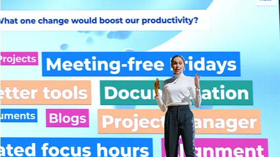 Presenter standing before a Kahoot word cloud survey asking employees what change would boost productivity
