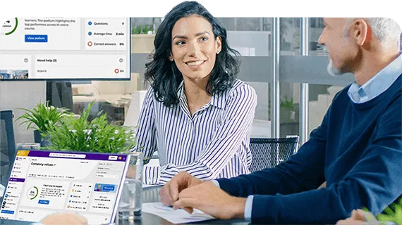 3 people say around a table with Kahoot on screen behind