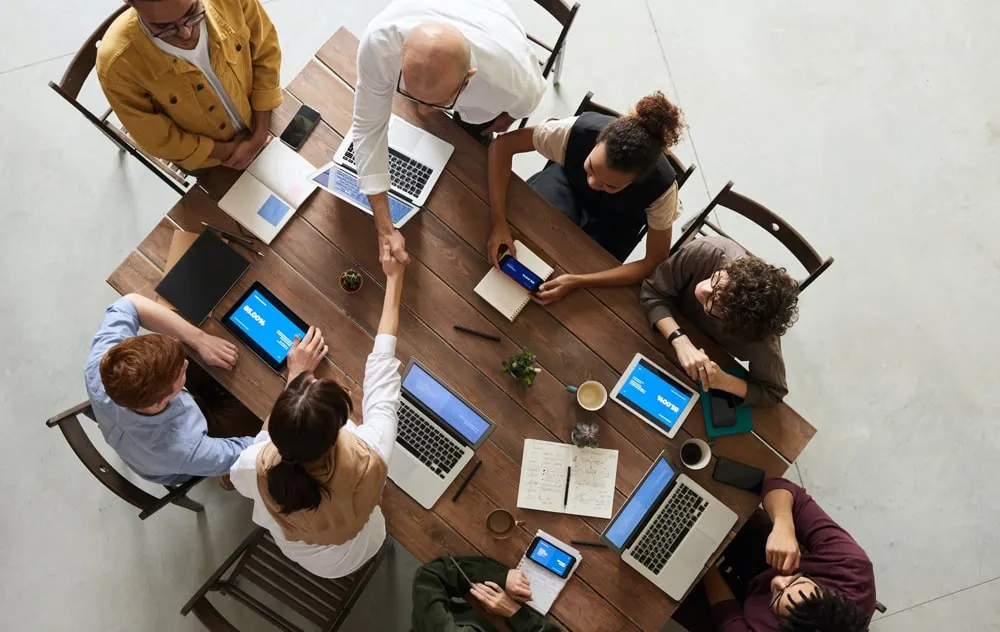 Team of colleagues at a desk with their laptops