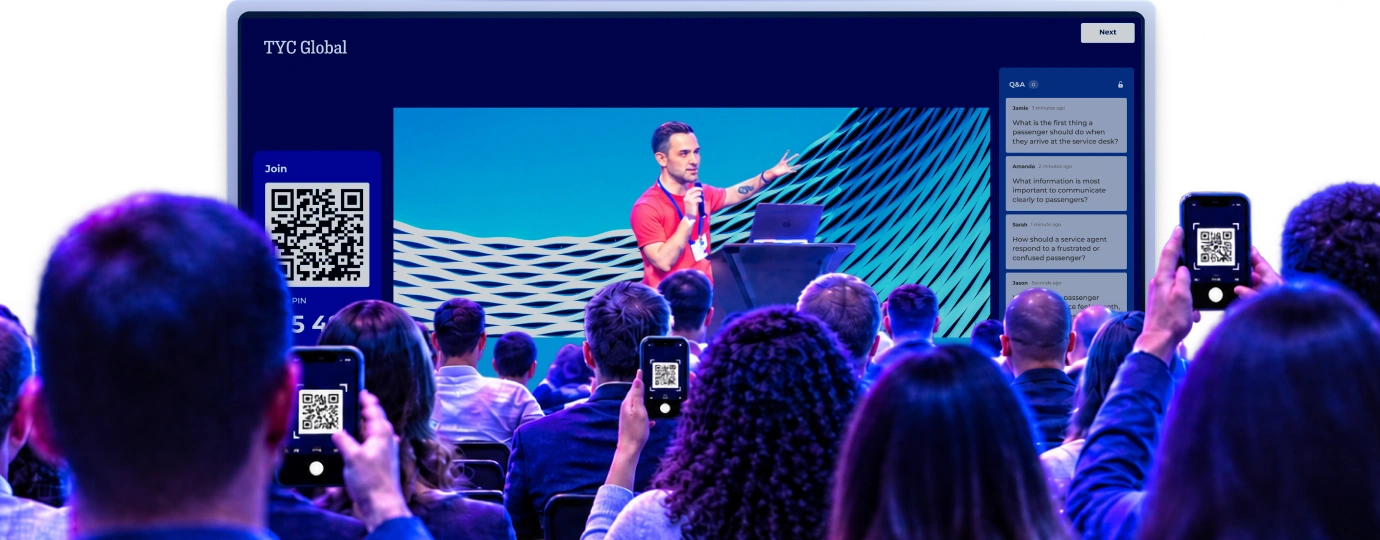 Conference audience scanning QR codes on their phones to join a Kahoot session with a live Q&A sidebar visible on the presentation screen
